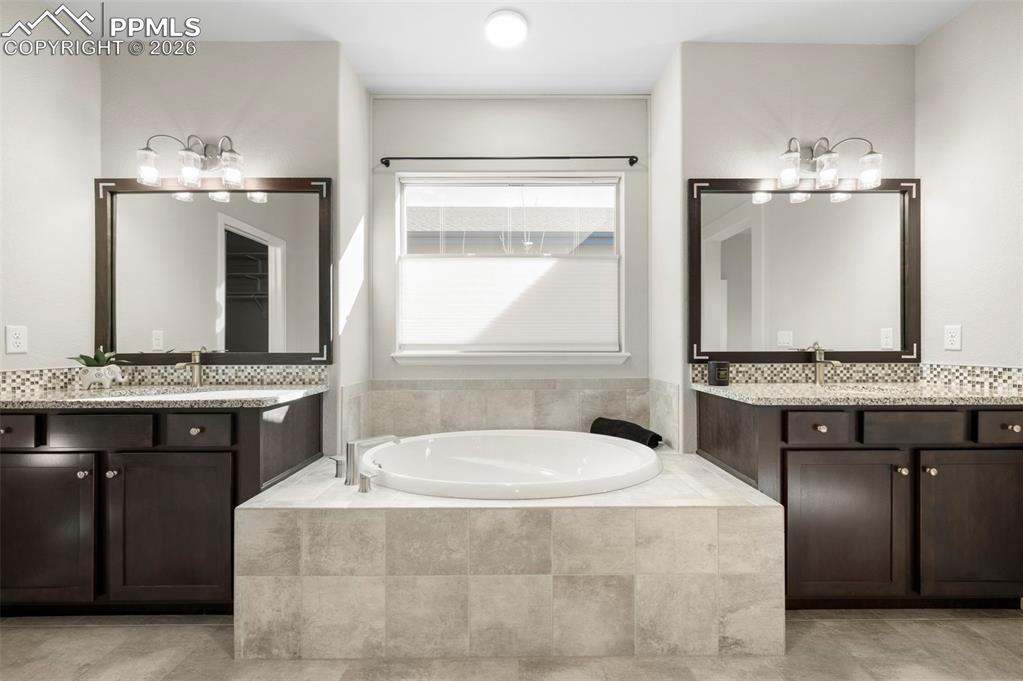 Bathroom with two vanities and a bath