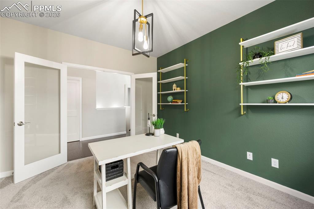 Office with light colored carpet and baseboards