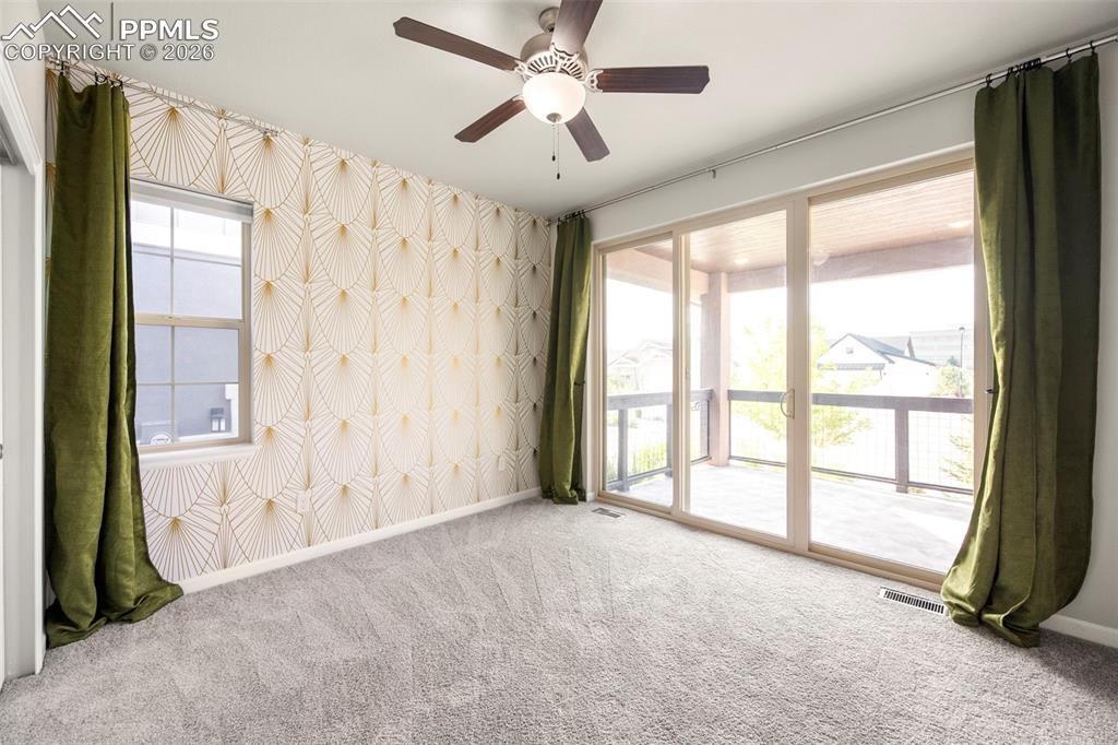 Unfurnished room featuring wallpapered walls, ceiling fan, and carpet floors