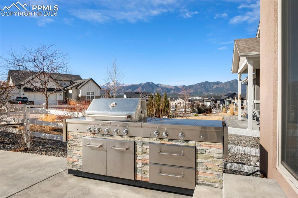 View of patio with area for grilling, a residential view, and a mountain view