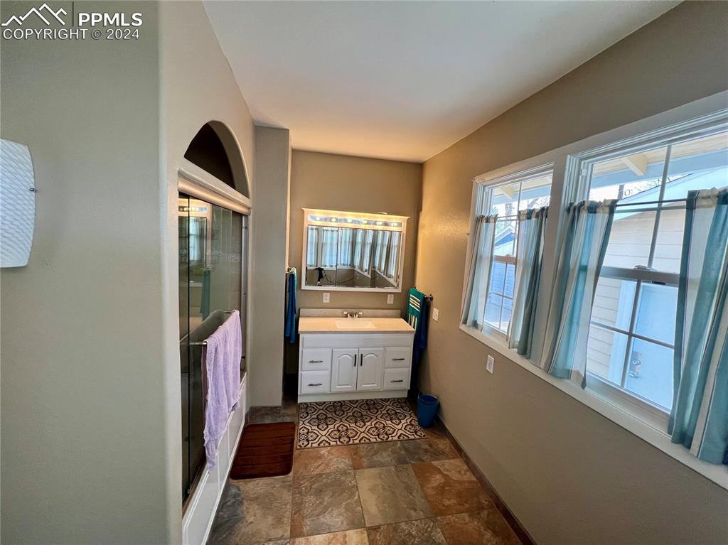 Bathroom with tile flooring and vanity with extensive cabinet space