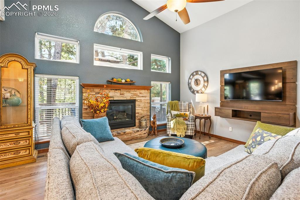 Wall of windows surround the stacked stone gas fireplace