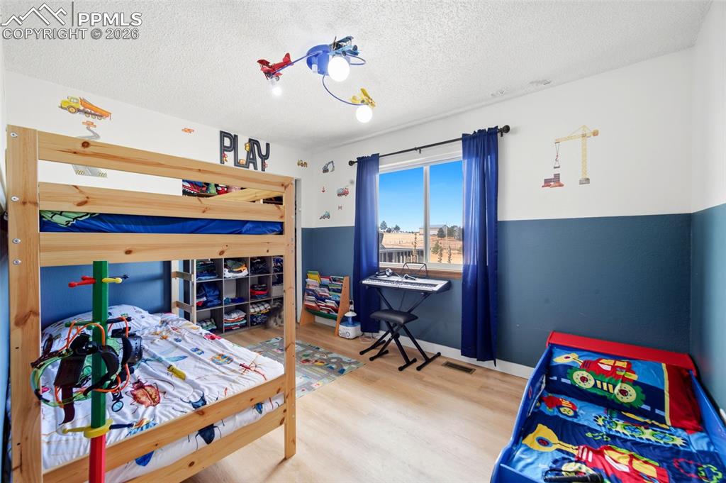 Bedroom featuring a textured ceiling and wood finished floors