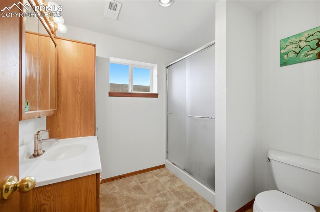 Bathroom featuring vanity, a shower stall, and light tile patterned floors