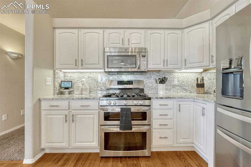 Any home chef will appreciate the polished granite counters and the double convection oven with warming function, offering a well-equipped space for creative cooking