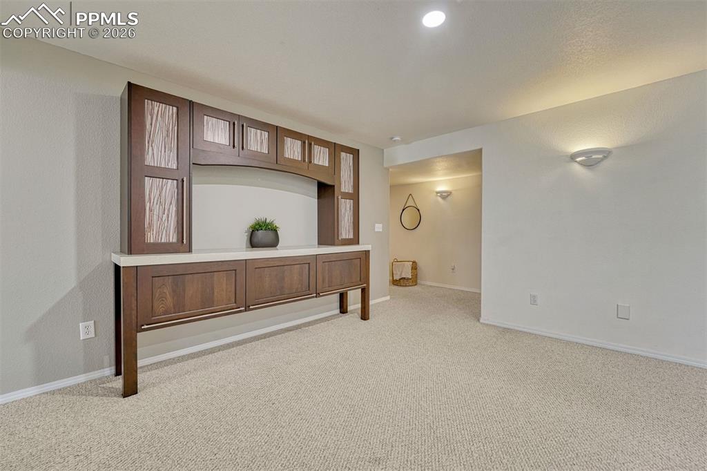 Downstairs offers additional living or flex space and continues the home’s calm, cohesive palette