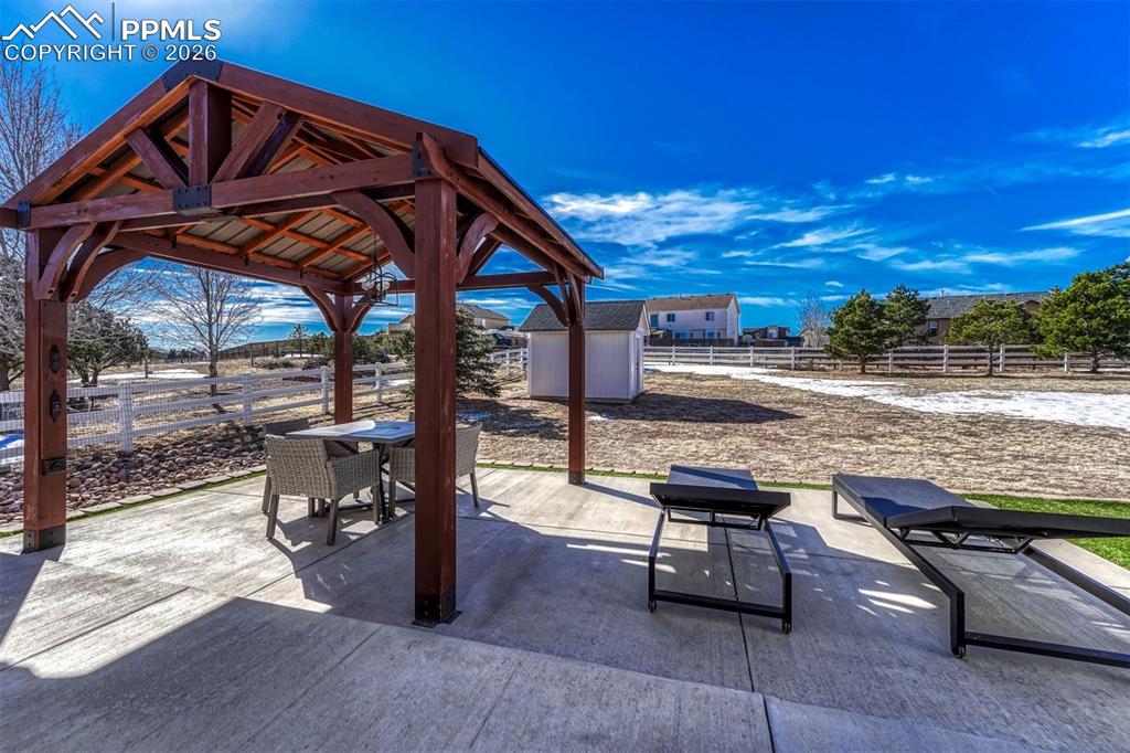 The extended back patio steps down to a covered pergola, creating a relaxing spot to unwind and take in the sunset