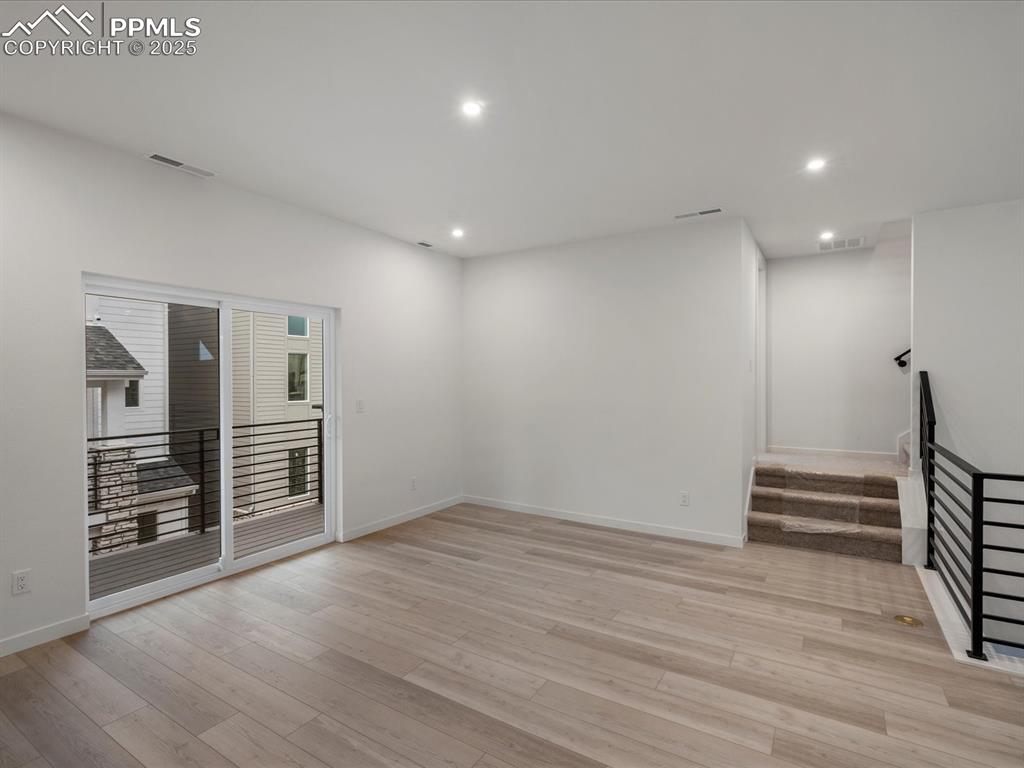 Unfurnished room featuring stairs, recessed lighting, and light wood-type flooring