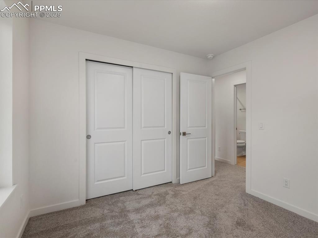 Unfurnished bedroom featuring carpet and a closet