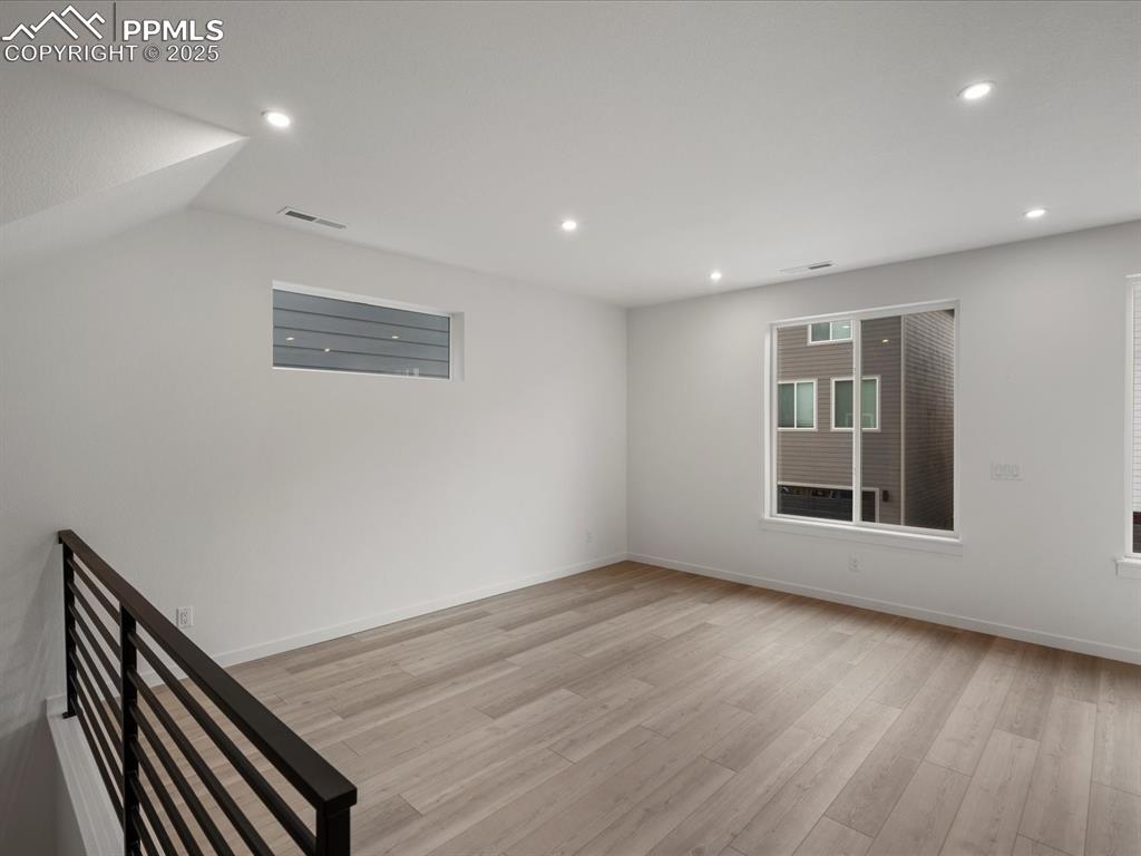 Empty room featuring light wood finished floors and recessed lighting