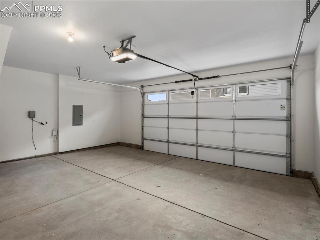 Garage with electric panel and a garage door opener