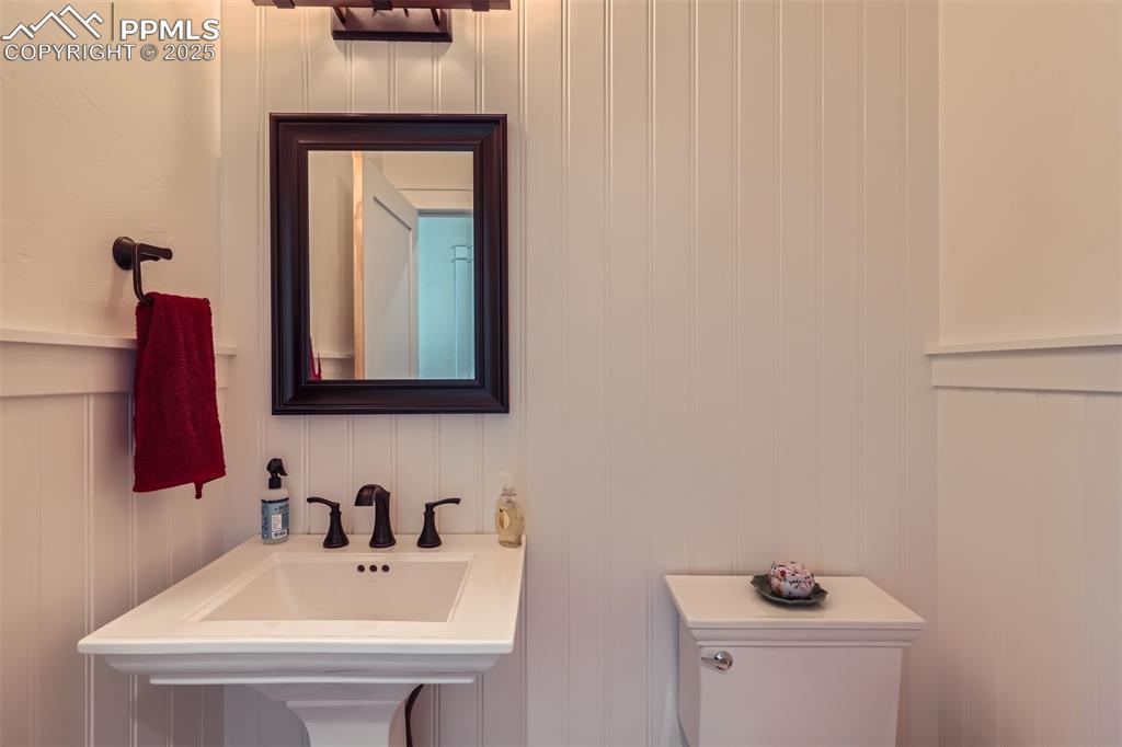 Half-bathroom with a decorative wall wainscot and toilet
