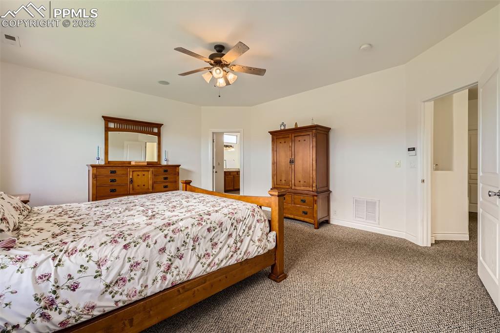 Master bedroom with carpet flooring and a ceiling fan