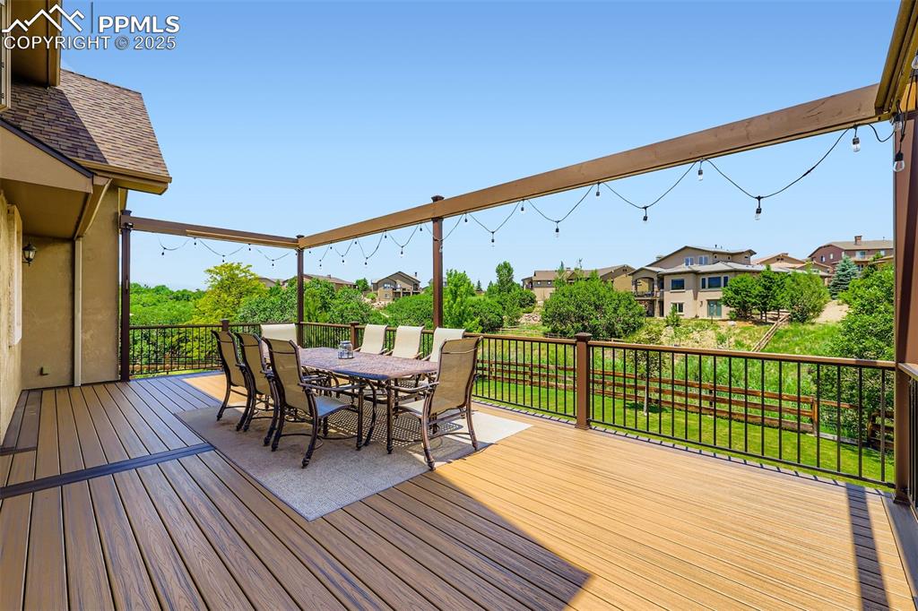 Custom composite deck featuring outdoor dining area and an open space/green space view