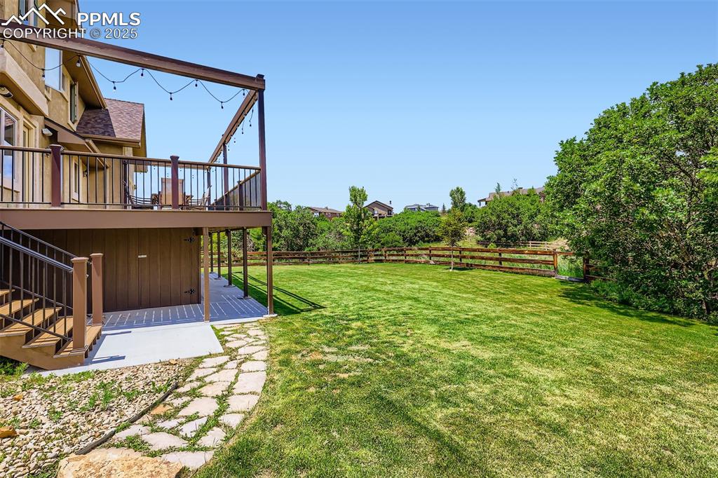 Fenced backyard featuring stairs and a custom composite deck
