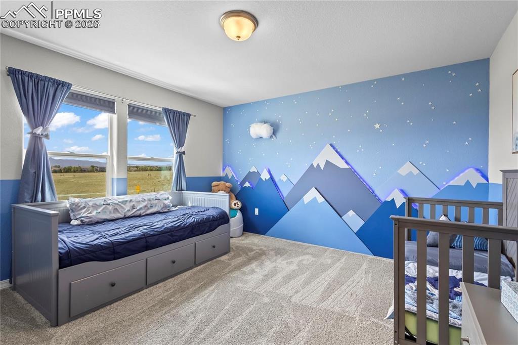 Bedroom featuring an accent wall, wallpapered walls, and carpet flooring