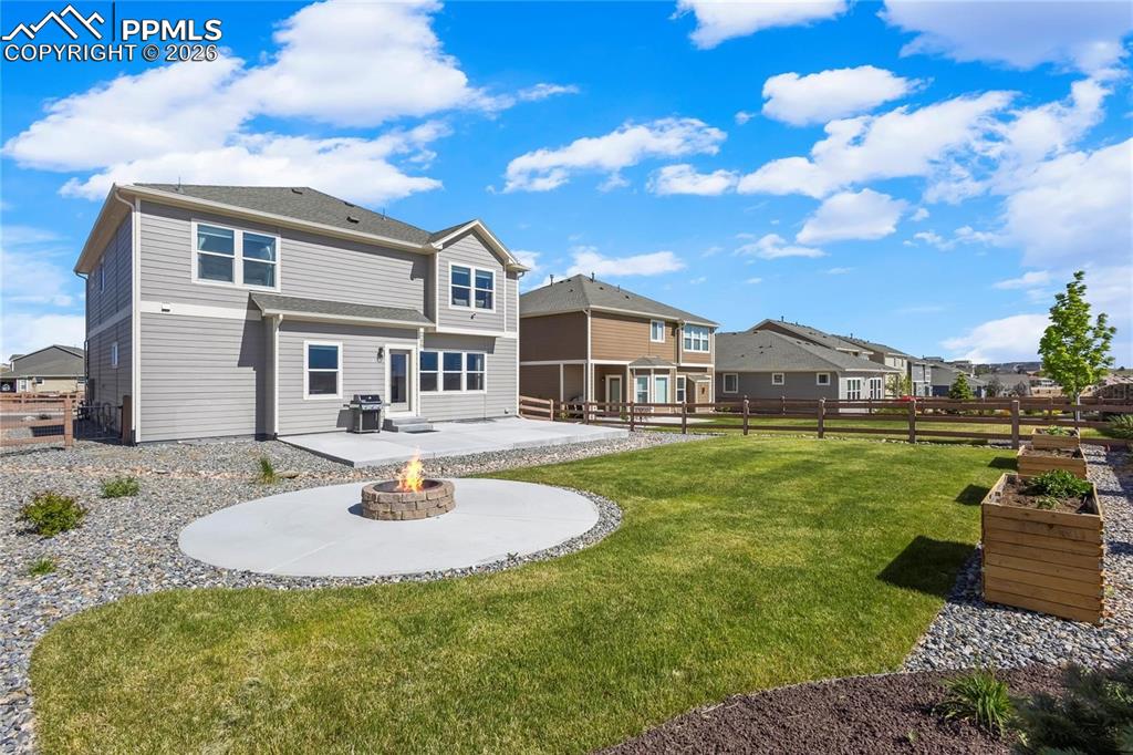 Rear view of house with a patio area, a residential view, a fenced backyard, and a fire pit