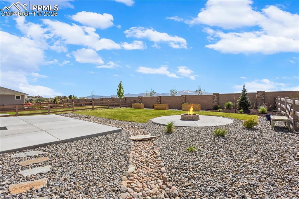 Fenced backyard with a patio area and an outdoor fire pit