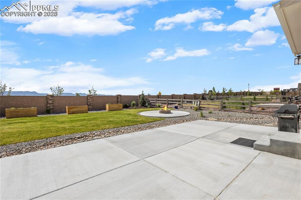 Fenced backyard featuring a patio and area for grilling