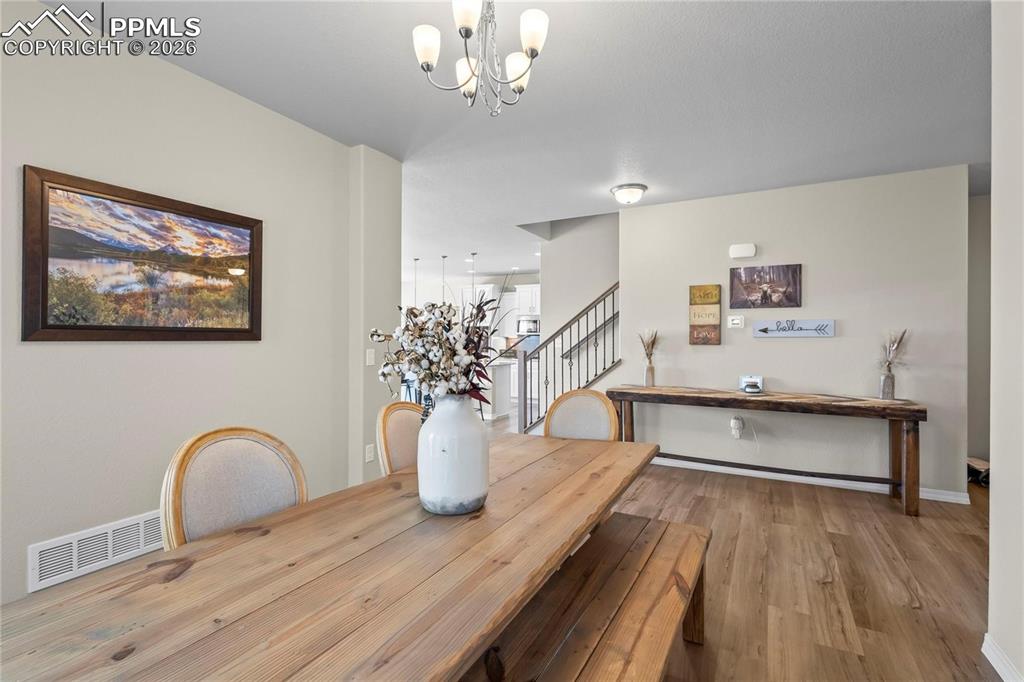 Dining space featuring wood finished floors and suspended lighting