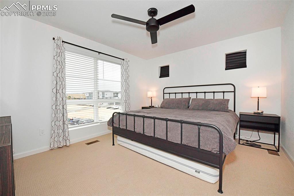 Bedroom with light carpet and ceiling fan