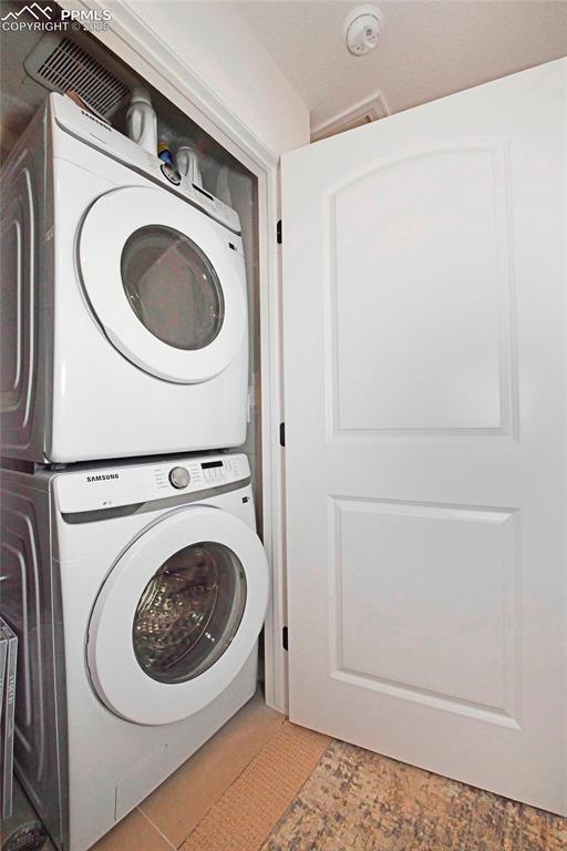 Laundry room featuring stacked washing machine and dryer
