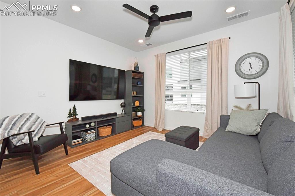 Living room featuring light wood-type flooring, recessed lighting, and a ceiling fan