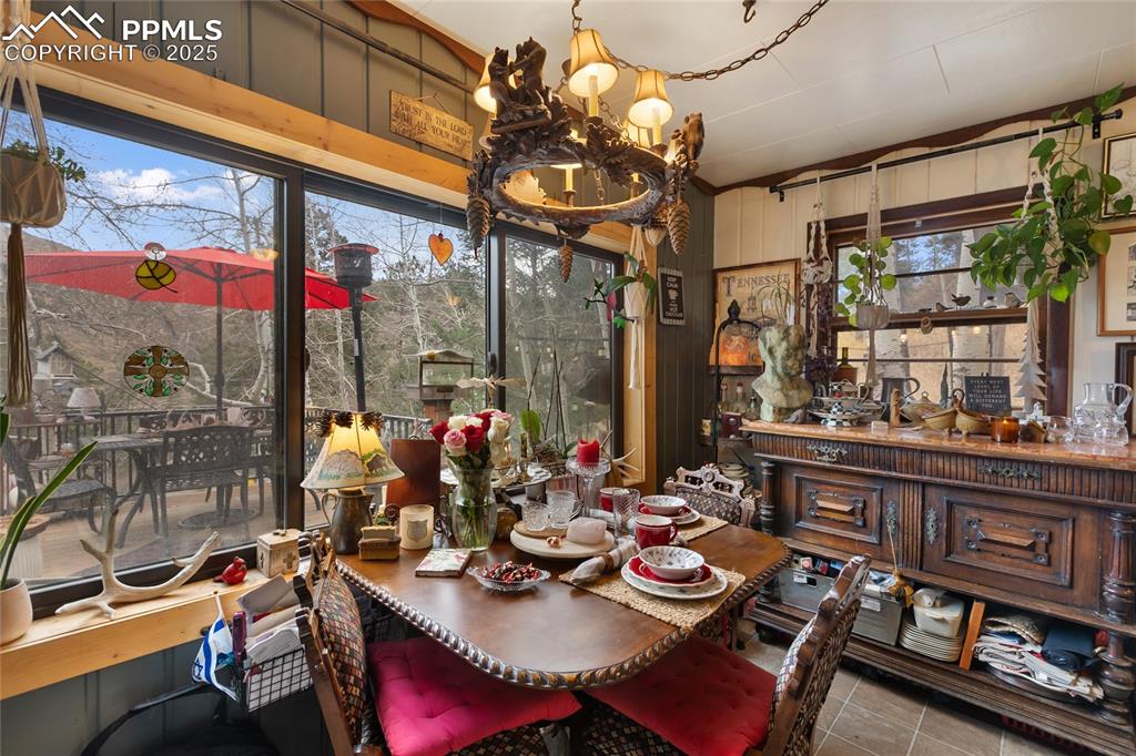 Tiled dining area with wooden walls and a chandelier