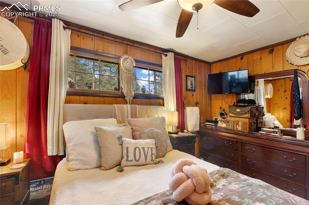 Main Bedroom with wood walls and ceiling fan