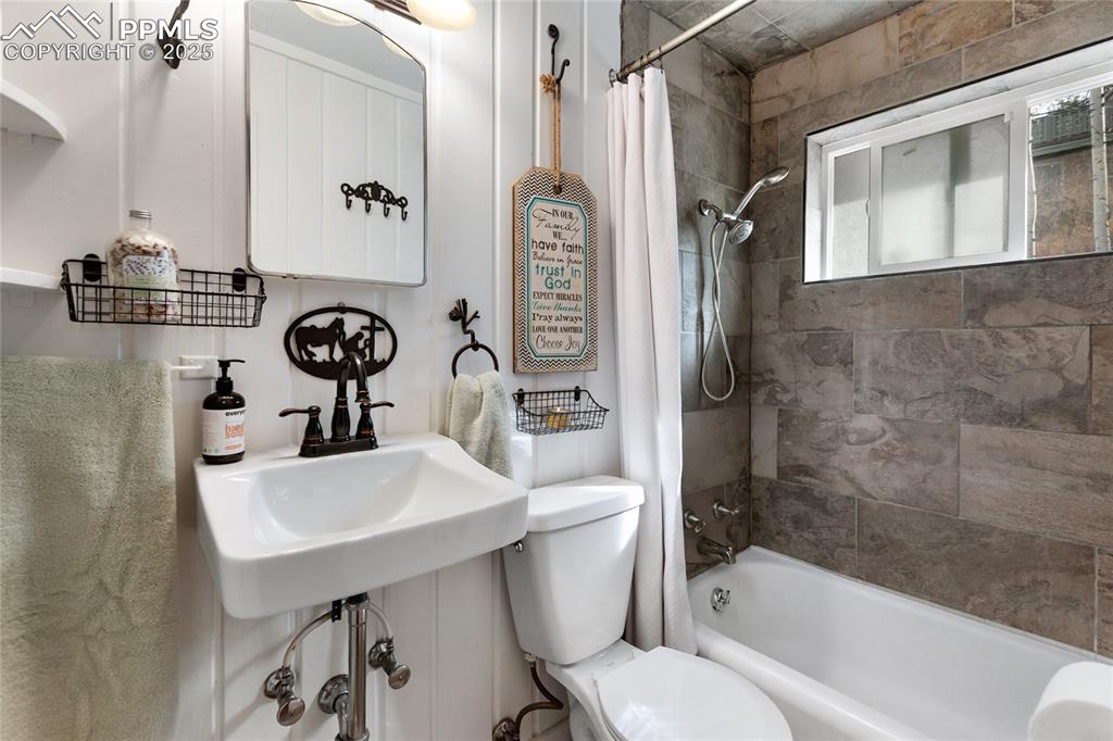 Full bath featuring toilet and shower / tub combo with curtain