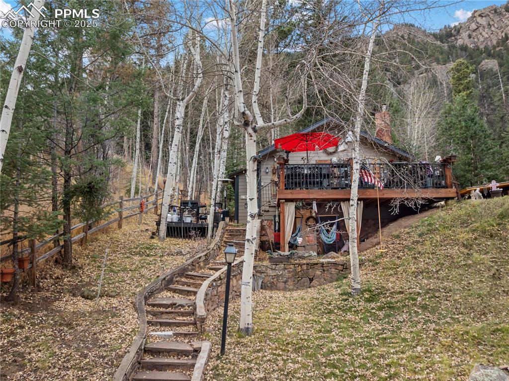 View of yard with stairs and a wooden deck