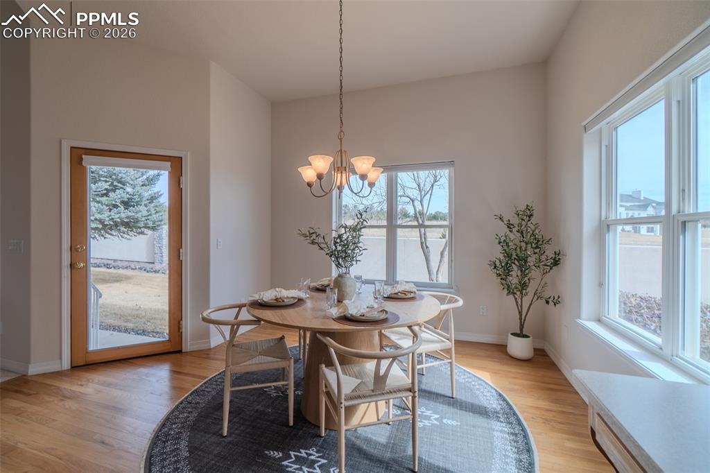 Dining area with light wood-type flooring and hanging lights
