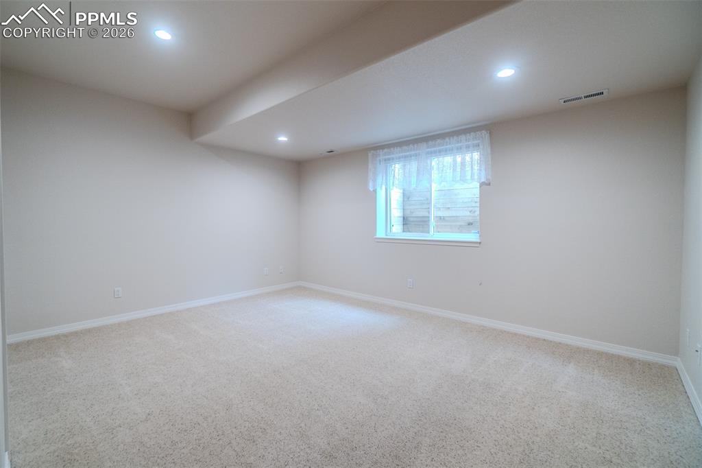 3rd bedroom in basement featuring light carpet and recessed lighting
