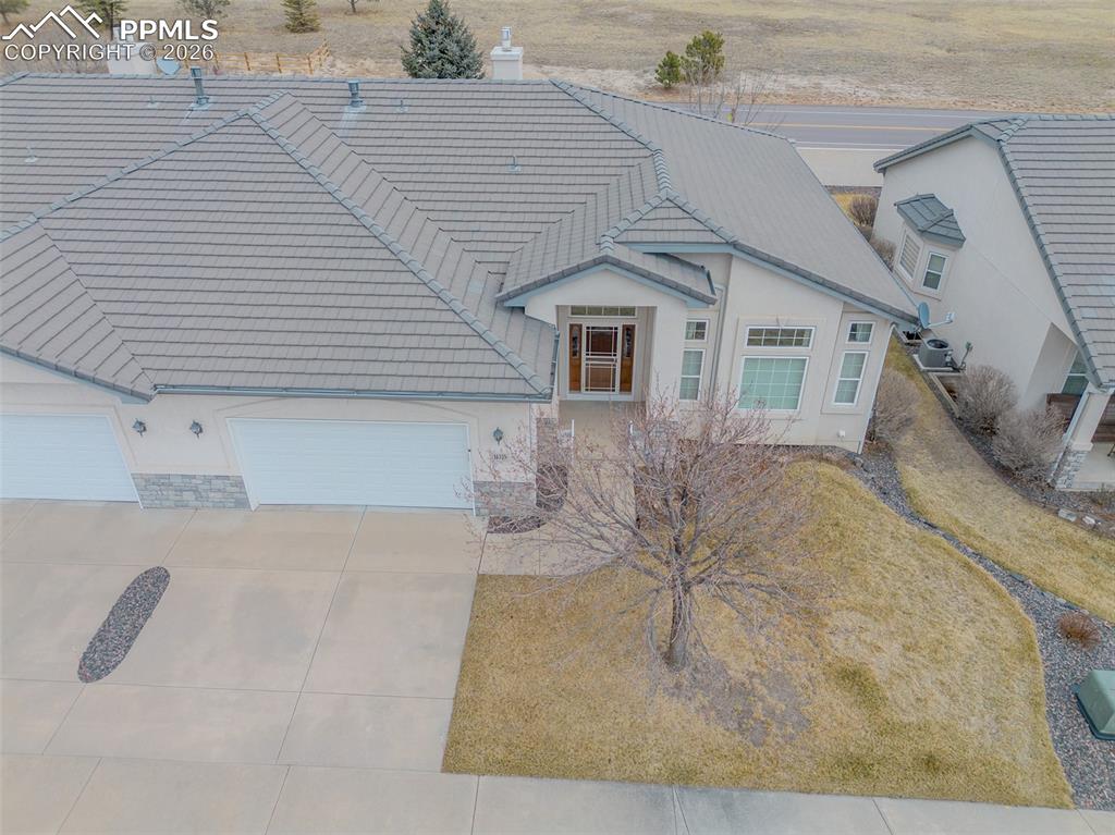 View of front of house with a tile roof, 2 car garage, and stucco siding.