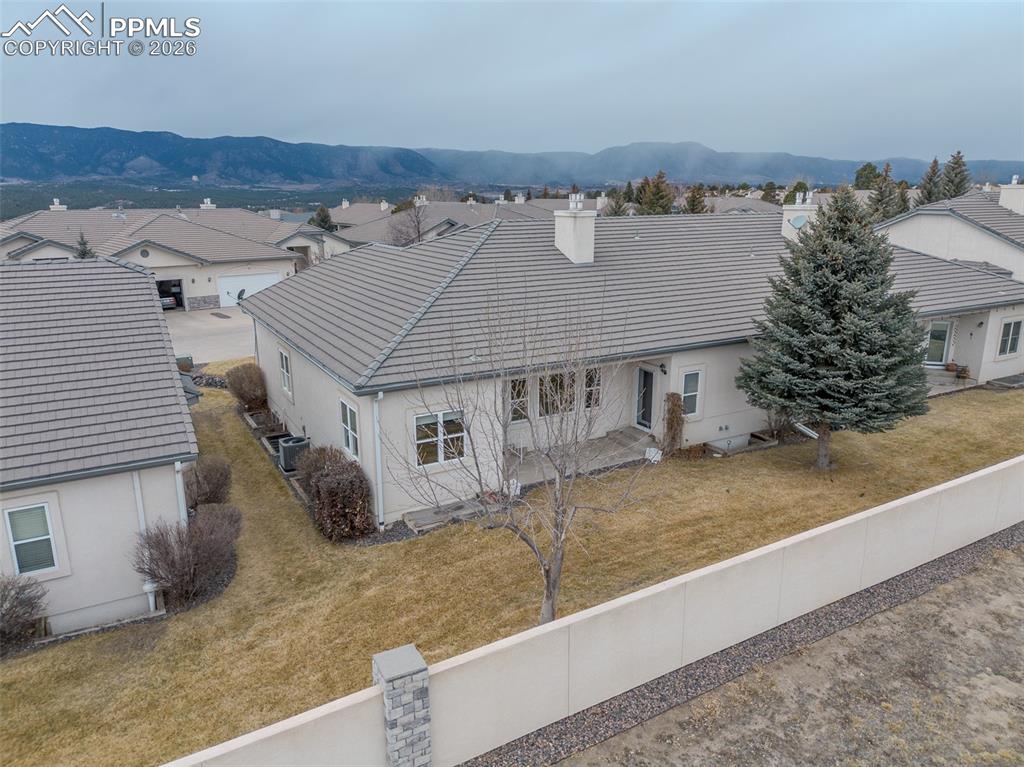 View of back of property featuring a chimney, a tile roof, stucco siding, no private fencing