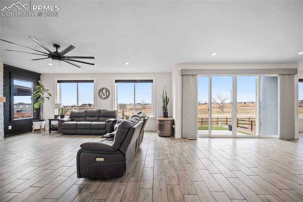 Living room with ceiling fan, recessed lighting, and wood finished floors