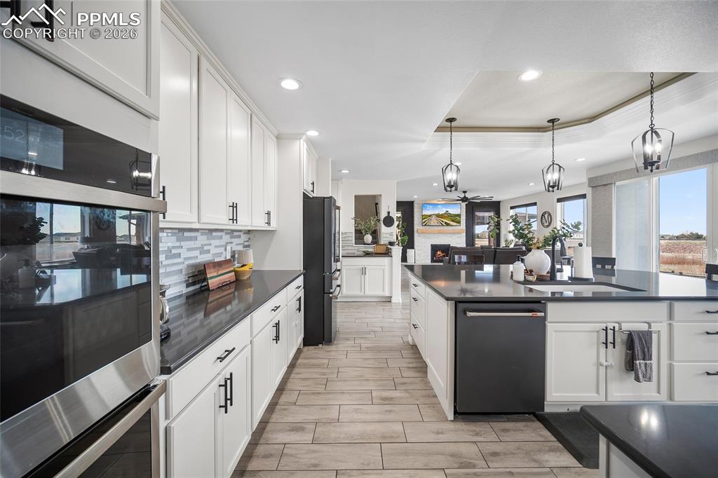 Kitchen with freestanding refrigerator, tasteful backsplash, recessed lighting, a sink, and dark countertops