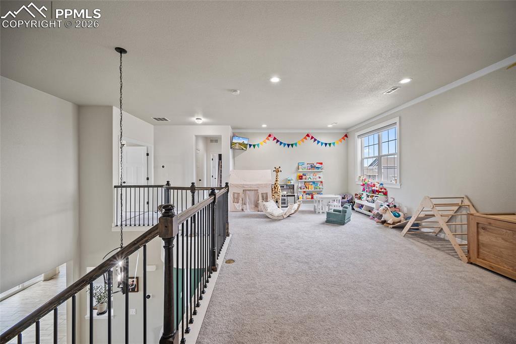 Playroom with carpet flooring, ornamental molding, visible vents, and recessed lighting
