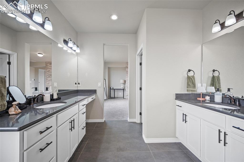 Full bathroom with a sink, tile patterned floors, and two vanities