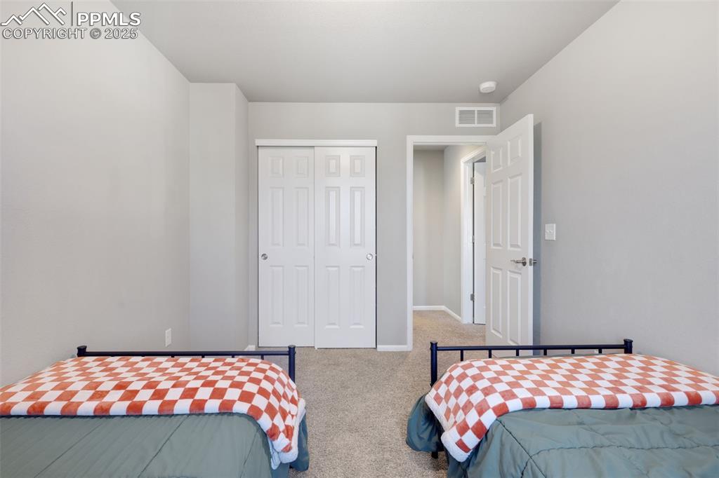 Carpeted bedroom featuring a closet and baseboards