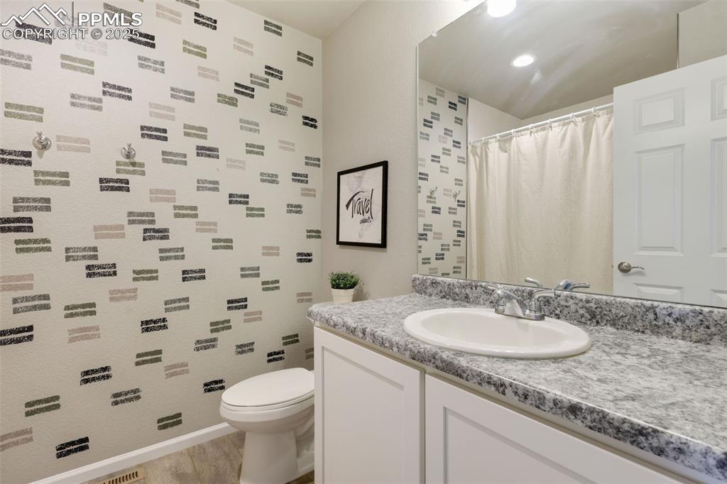 Full bathroom featuring vanity, light wood-type flooring, and a shower with shower curtain