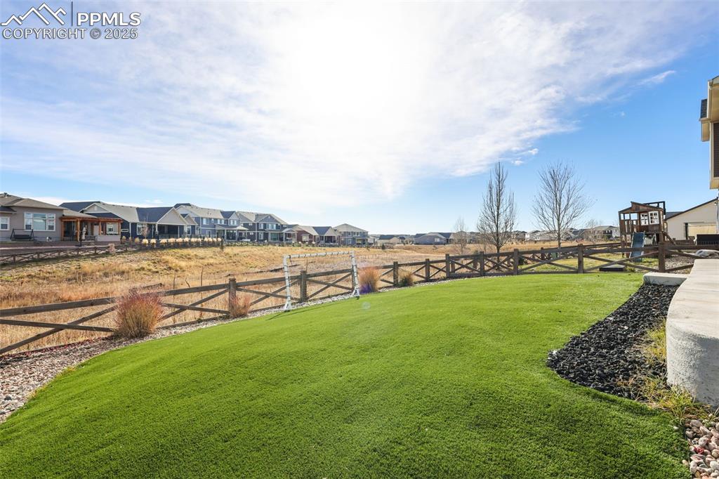 Fenced backyard featuring a residential view