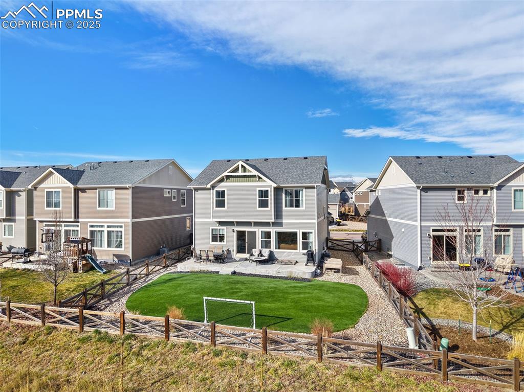 Rear view of property with a patio area, a residential view, a fenced backyard, and a playground