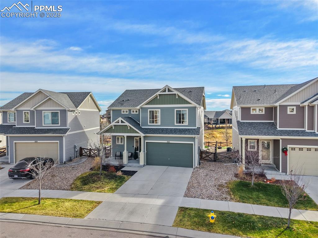 Craftsman-style house with a residential view, an attached garage, covered porch, concrete driveway, and roof with shingles