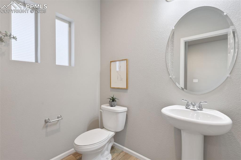 Bathroom with a textured wall and light wood-type flooring