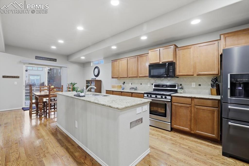 The kitchen has lots of can lights and natural lighting from the sliding glass doors. 