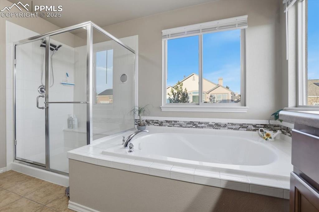 The primary bath has a large shower and a separate soaking tub with private views out the second-story windows. 