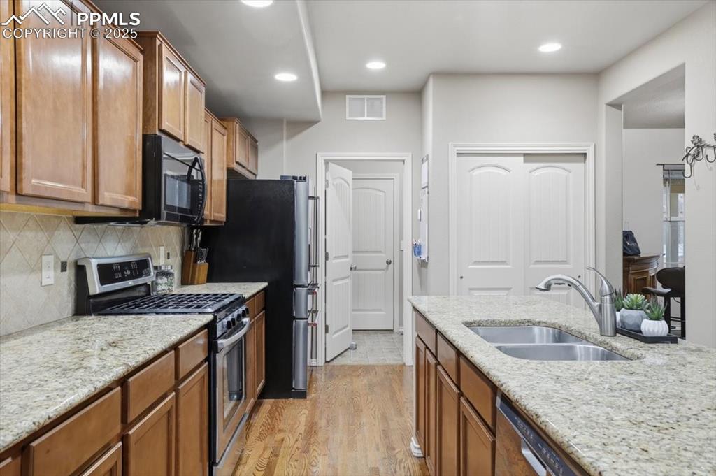 The kitchen has stainless steel appliances including a gas range. 