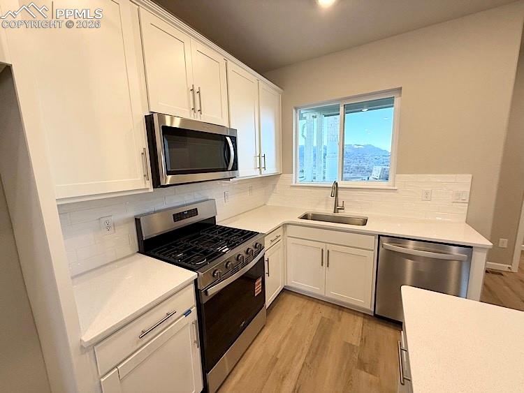 Kitchen with Quartz countertops, island, gas range, microwave, and dishwasher!