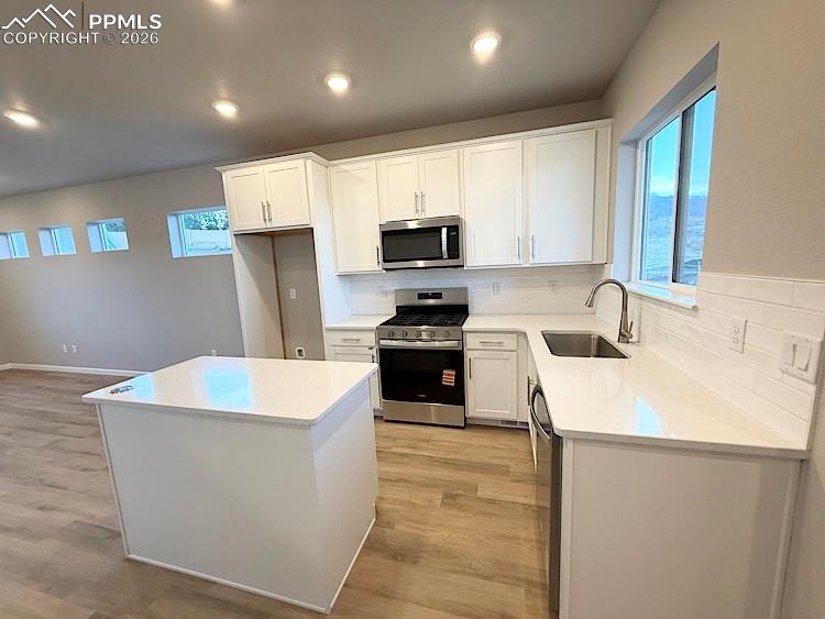 Kitchen with Quartz countertops, island, gas range, microwave, and dishwasher!